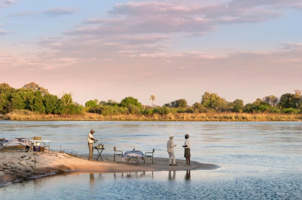 Have a picnic on a river island at Thorntree River Lodge. © African Bush Camps